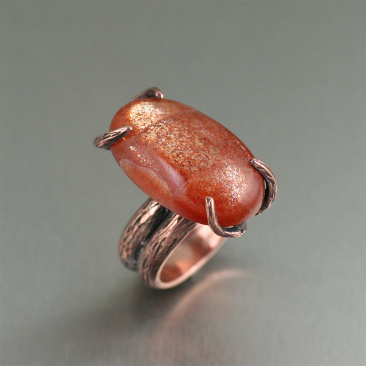 Uncover uncommon luxury in this Copper Bark Sunstone Handmade Ring. The nature-inspired, handcrafted branch texture is highlighted with a rich orange colored 29 carat Sunstone cabochon.