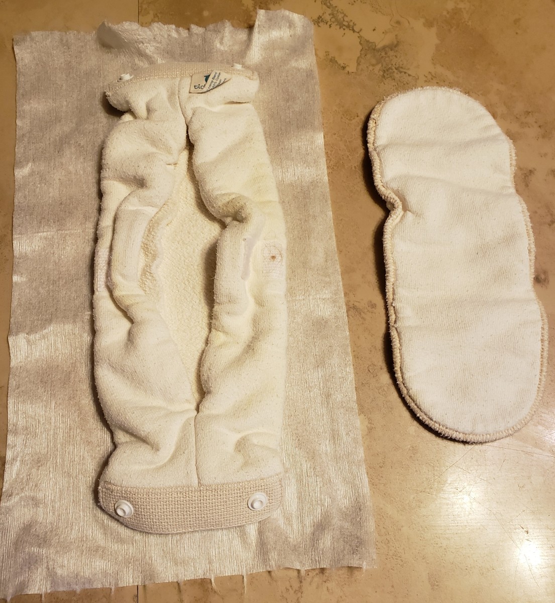 Diaper, Liner and Booster: the booster on the right slips inside the diaper on the left. Then the liner wraps around the whole thing, folding over the sides. Velcro holds the liner in place.