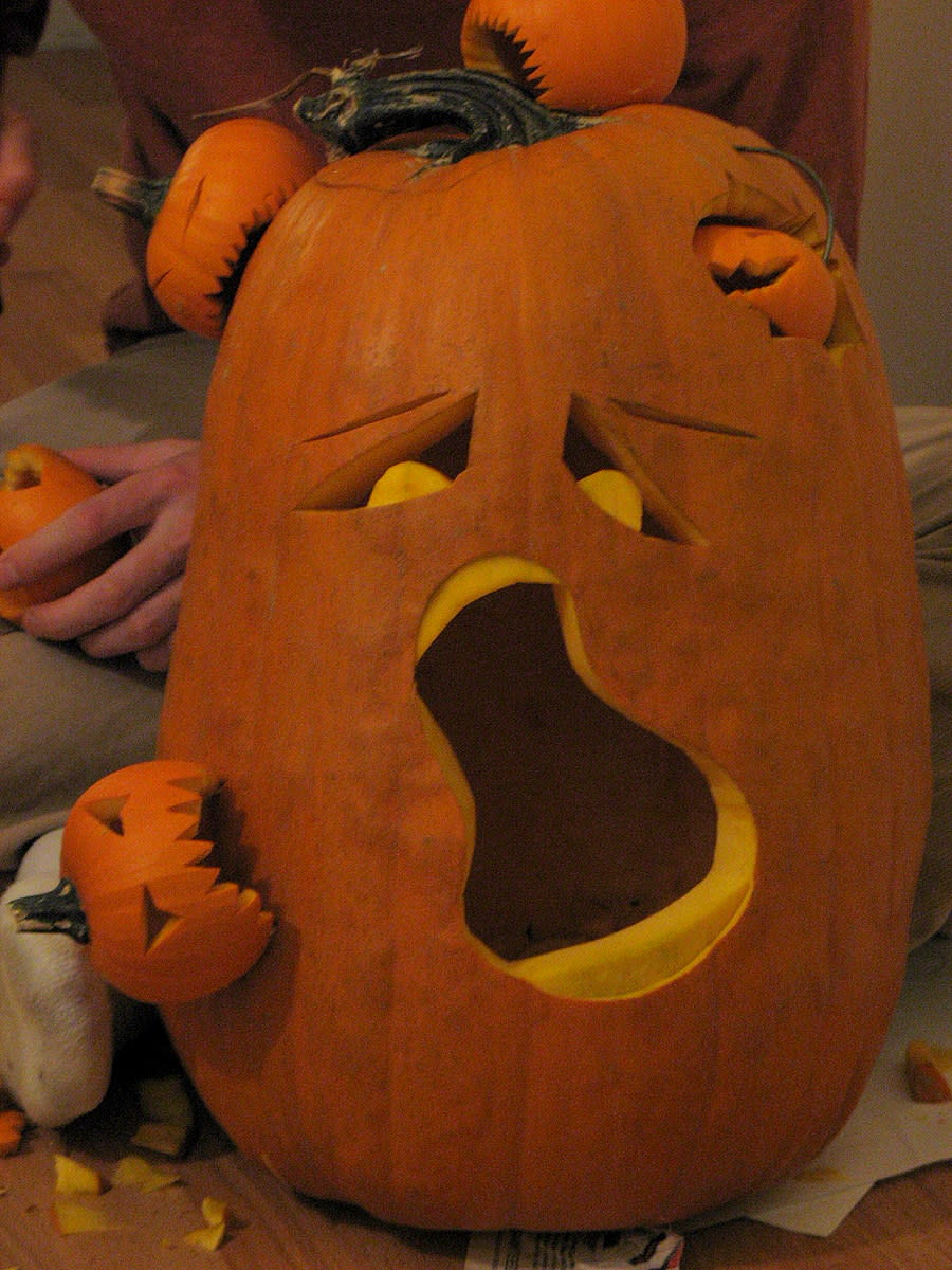 Creative pumpkin decorating using tiny pumpkins attached to a larger pumpkin.