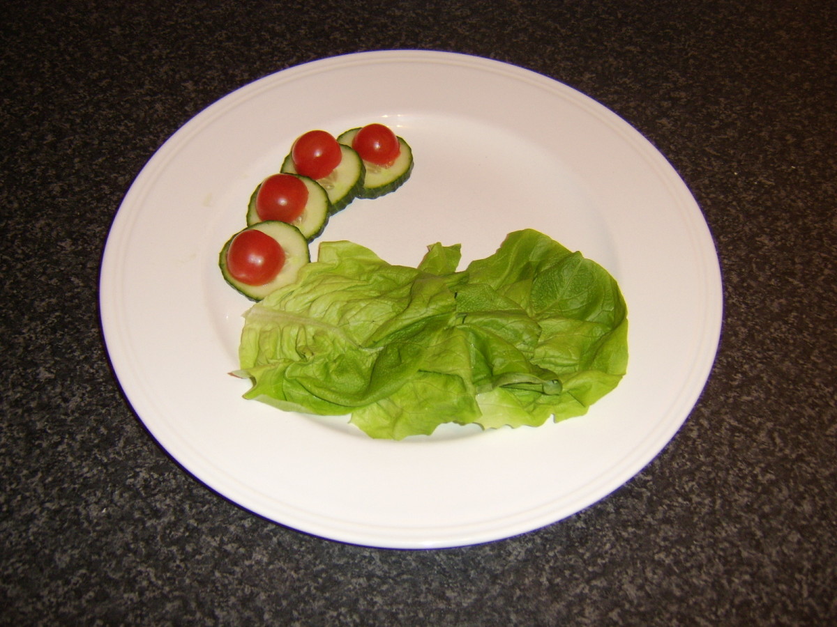 Salad arranged on the plate in preparation for the breaded coley fillet and chips