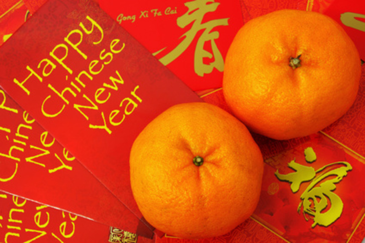 Mandarins ("kum" - meaning gold) with red packets filled with money. Image:  Mau Horng - Fotolia.com