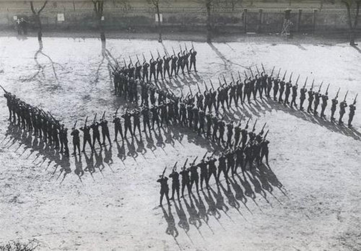 A German military unit posed in the form of the Nazi swastika