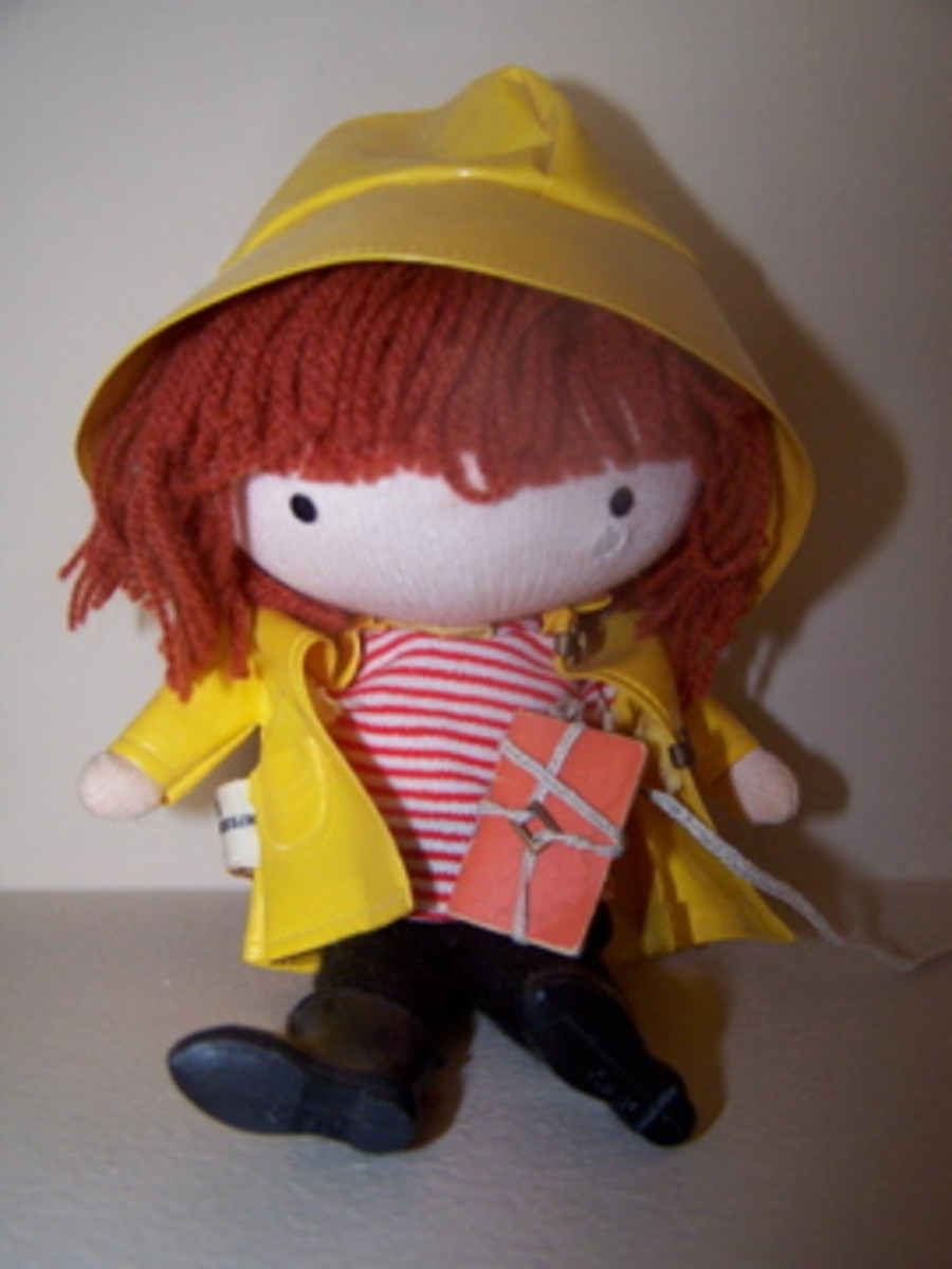 This Anglund Pocket Doll has its raincoat, rain hat, boots and book bag with string. 