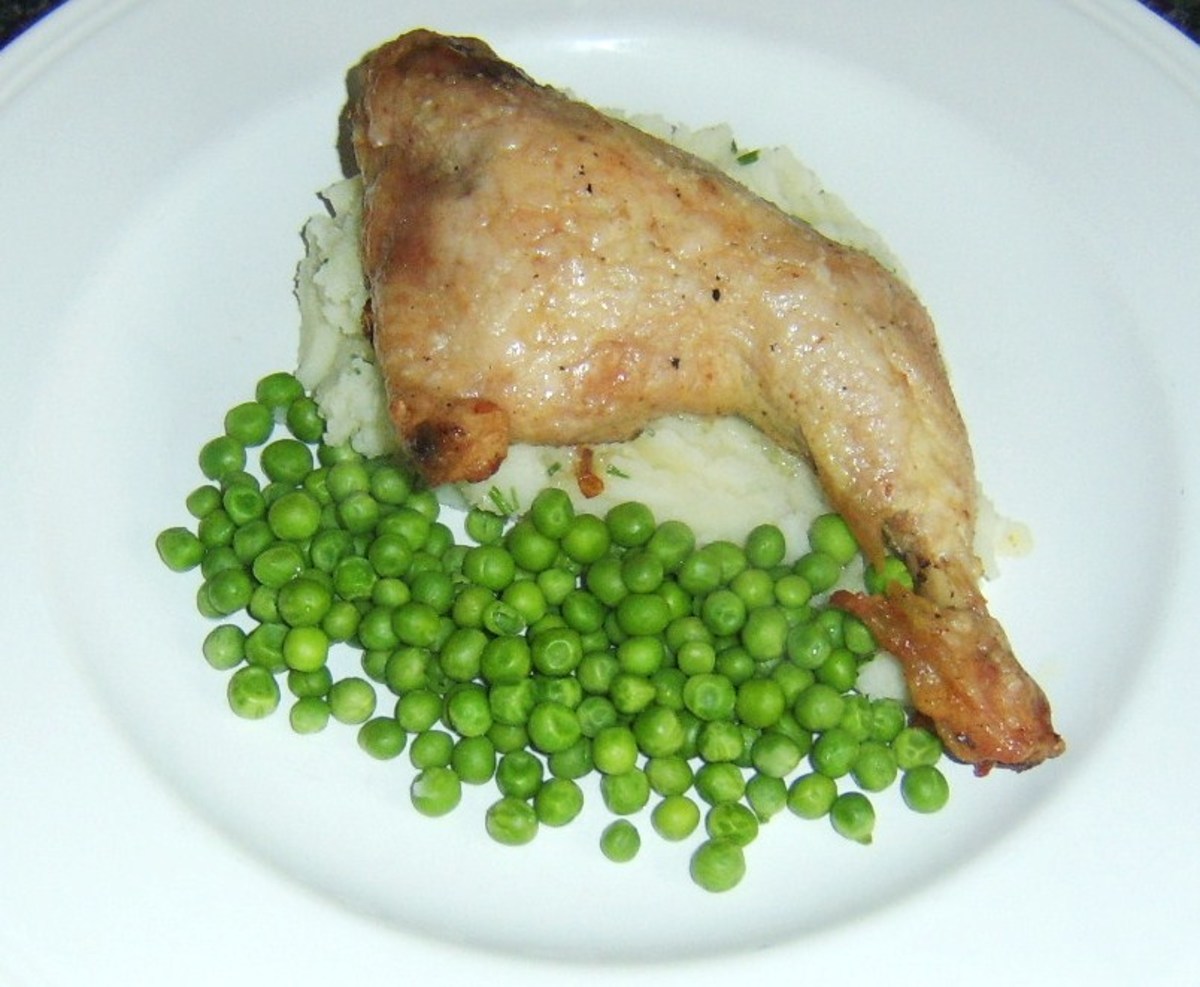 Simply roasted chicken leg is served on a bed of chive mashed potatoes and accompanied by garden peas