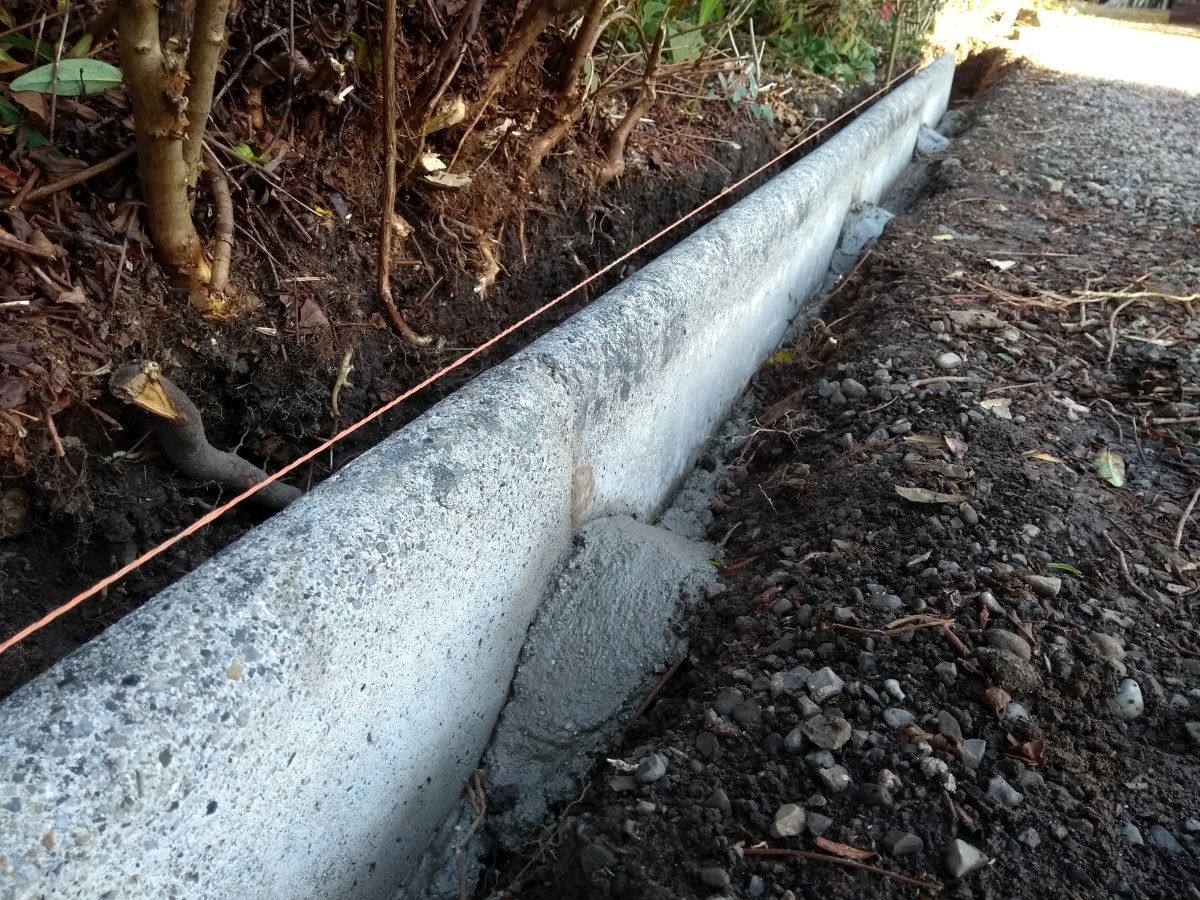 laying-concrete-edging-stones-along-a-driveway
