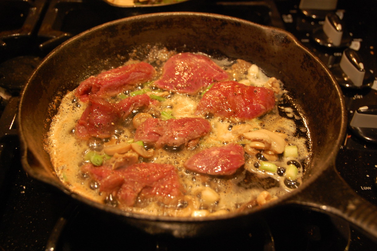 Tenderloins frying in butter, with garlic, mushrooms and green onions