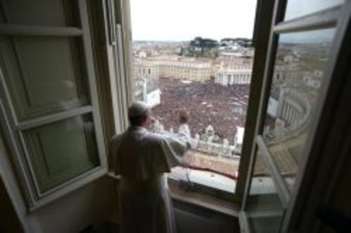 This handout picture released by the Press office shows Pope Francis waving to the crowd at St Peter's square during his first Angelus prayer at the Vatican on March 17, 2013. / AFP PHOTO/OSSERVATORE ROMANO
