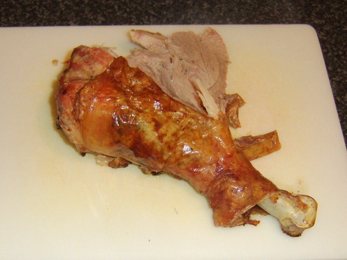 Starting to carve the meat from a turkey drumstick