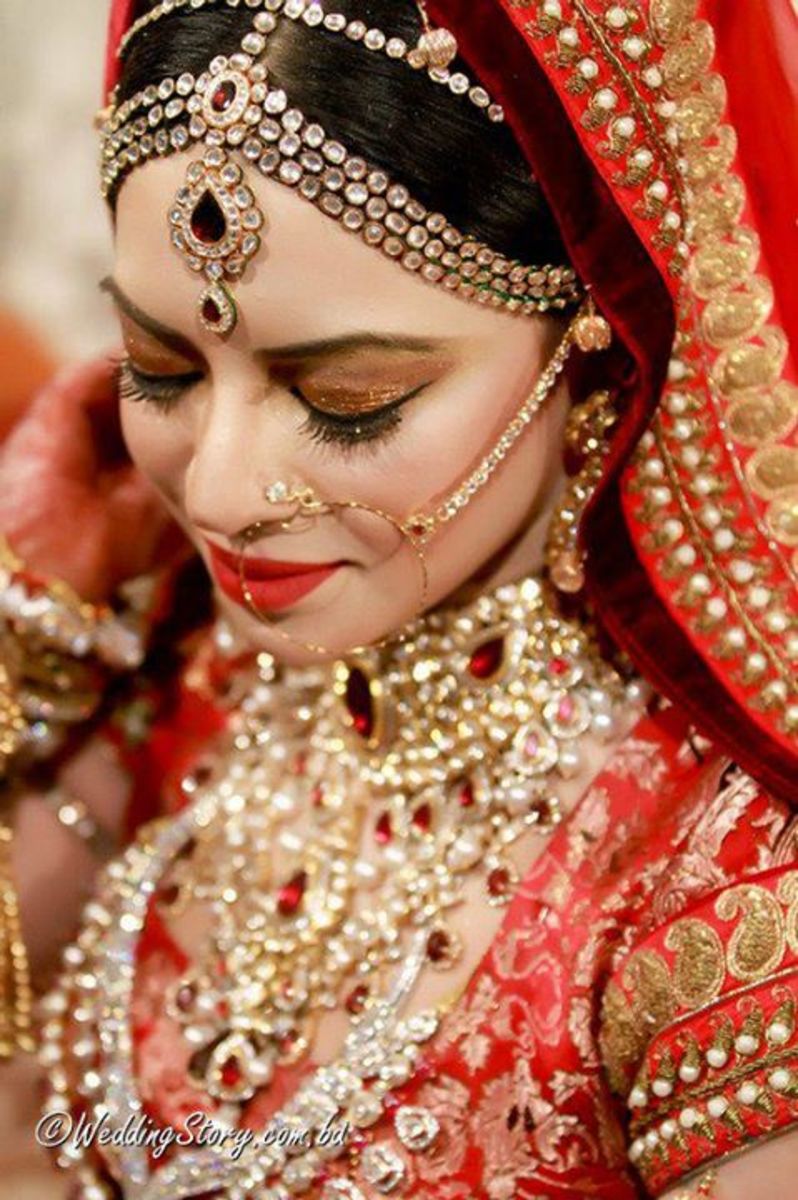 Beautiful bride by Farzana Shakil with gold eyes and lush red lips for her glamorous Bangladeshi wedding .
