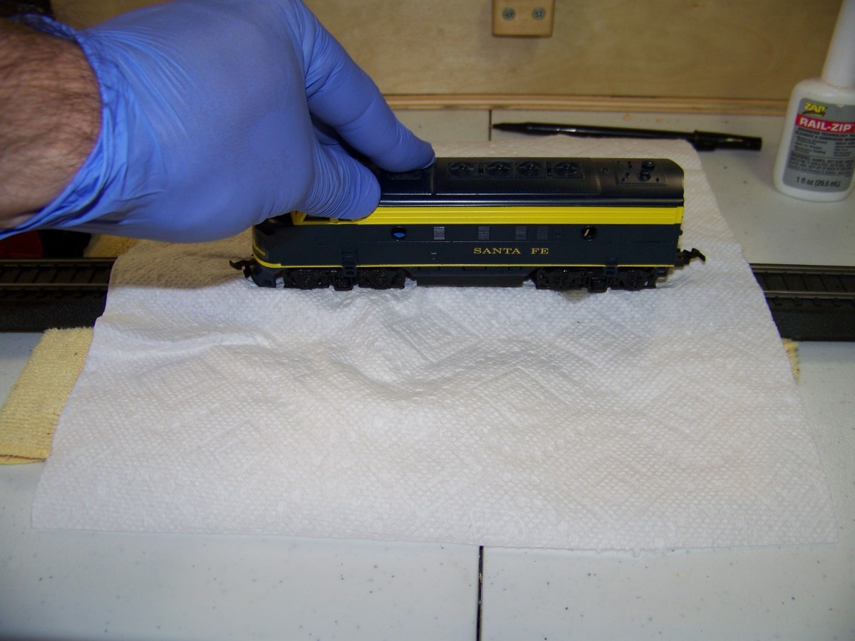 To clean non-powered wheels of locomotives, I drape a paper towel over a track segment then add a couple drops of Rail-Zip where the paper towel touches the rail head. I then place the locomotive on the track and move back an forth.