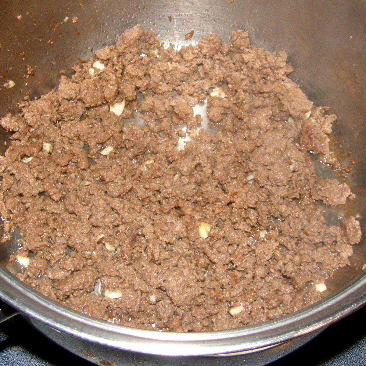 In a large pan (or pot) over medium heat, melt the butter & cook the ground beef until brown.  Add in your seasoning and spices.