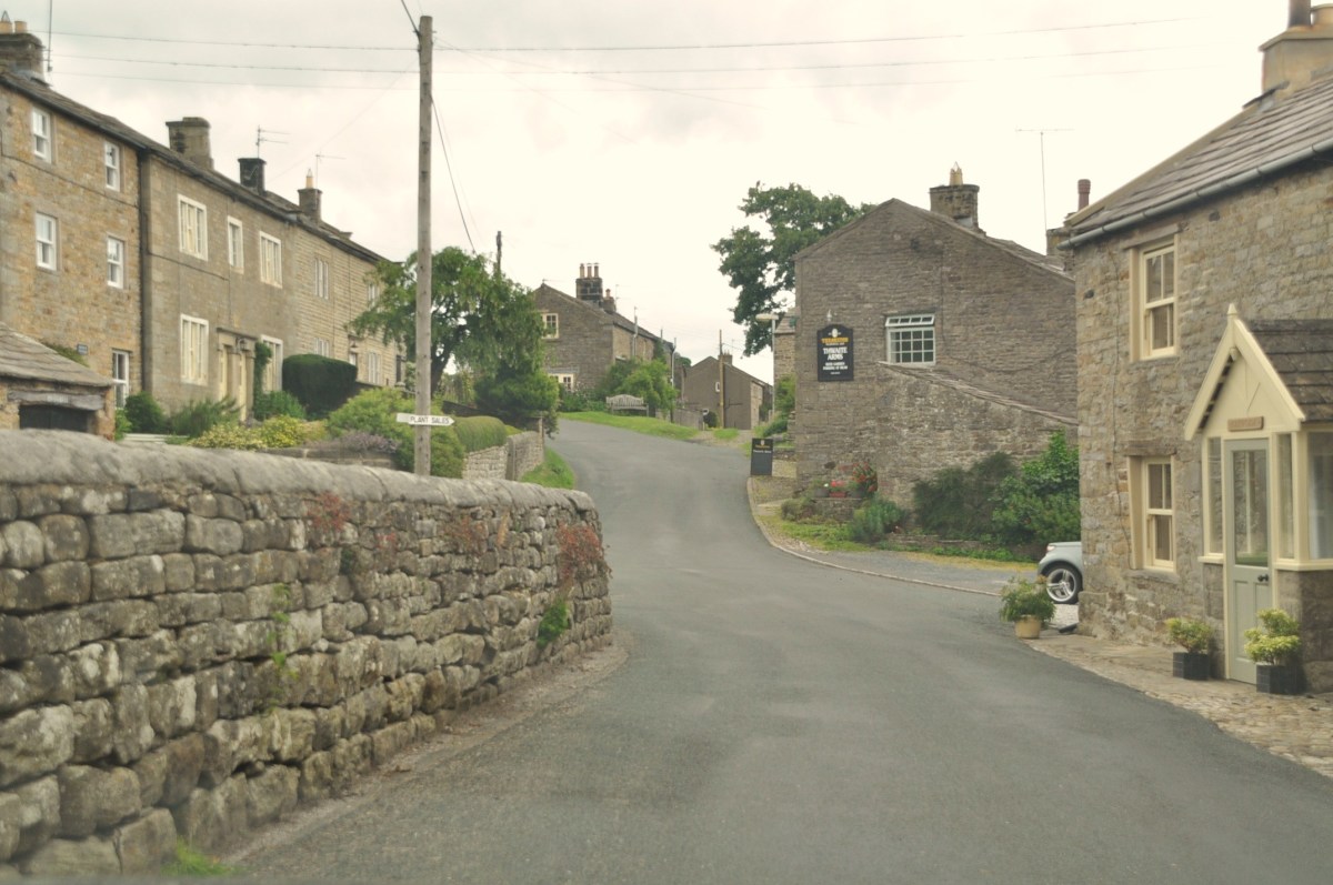 Horsehouse as you leave the village, The Thwaite Arms is on the right, where the stone wall seems to point