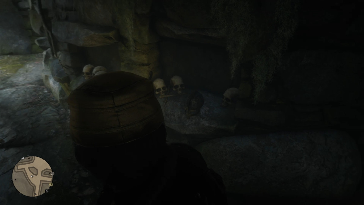 The Viking Helmet is on a stone shelf next to skulls. 