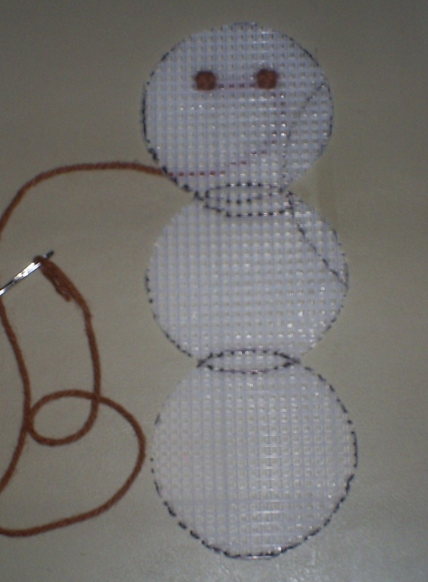Here I use a cross stitch technique to create the snowman's eyes.