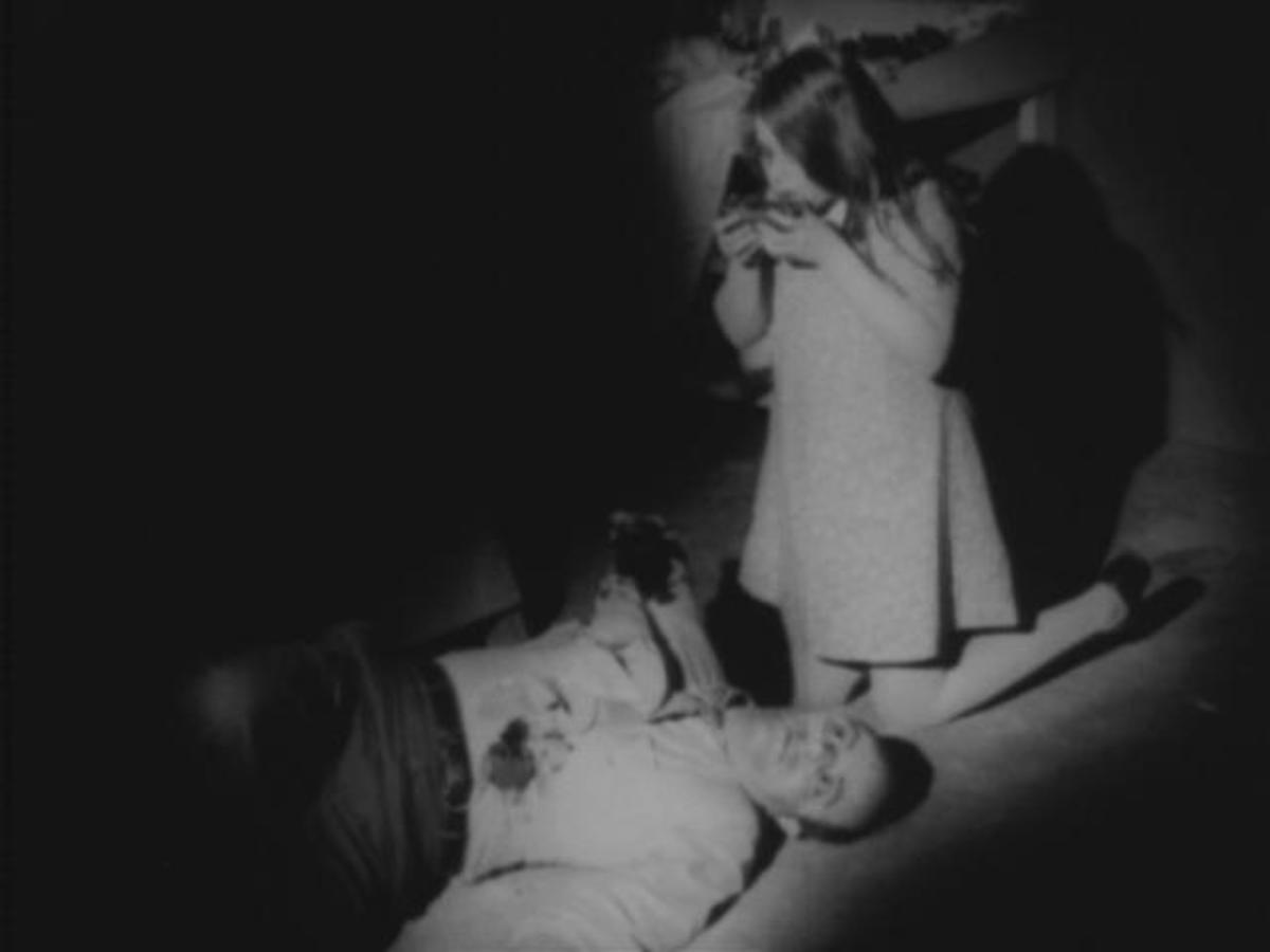 Night of the Living Dead screenshot -- a young zombie (Kyra Schon) and her victim (Karl Hardman). Direction and cinematography both by George A. Romero