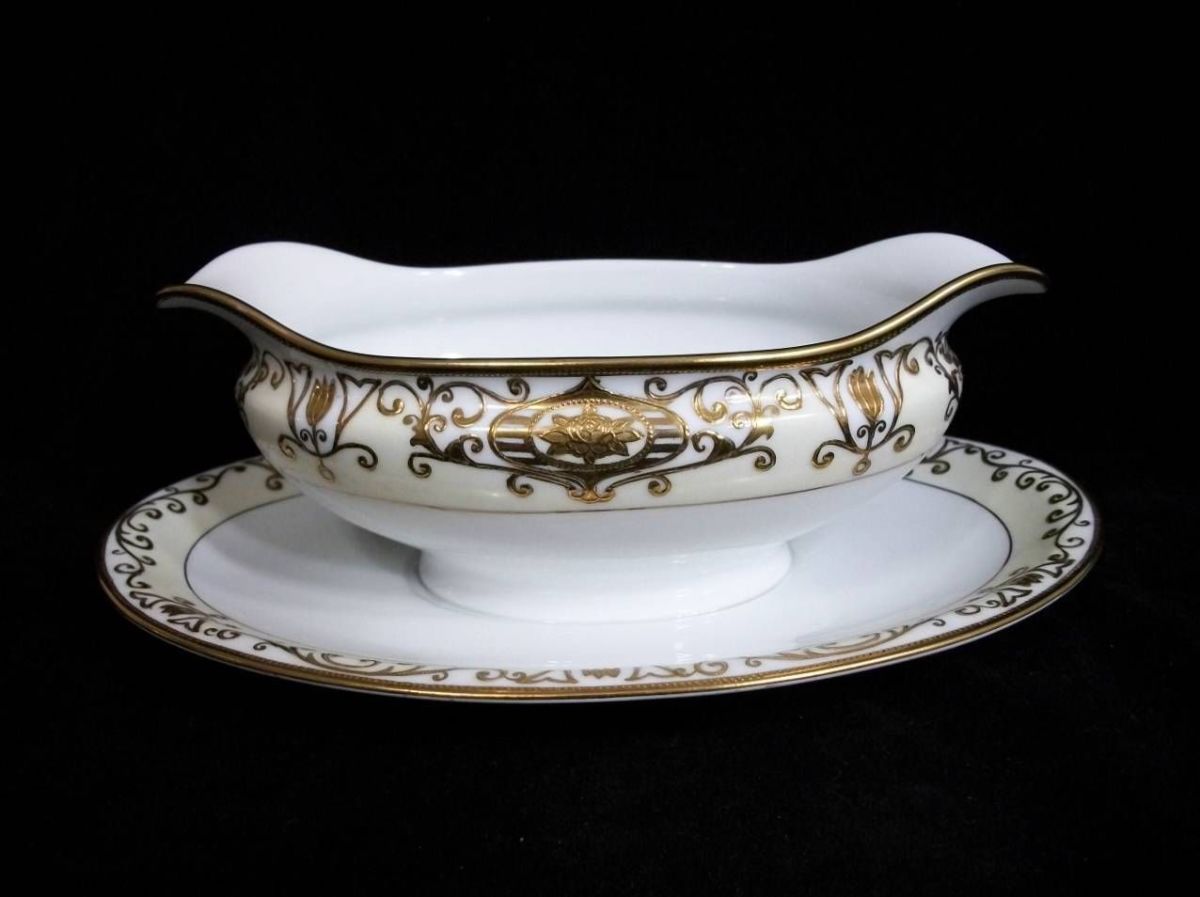 This is the Noritake #175 gravy boat with attached plate. It has a gold mark: 16034 Christmas Ball.
