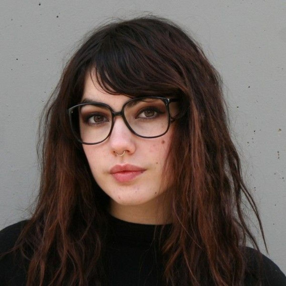 Picture of a young woman wearing oversized dark framed spectacles 