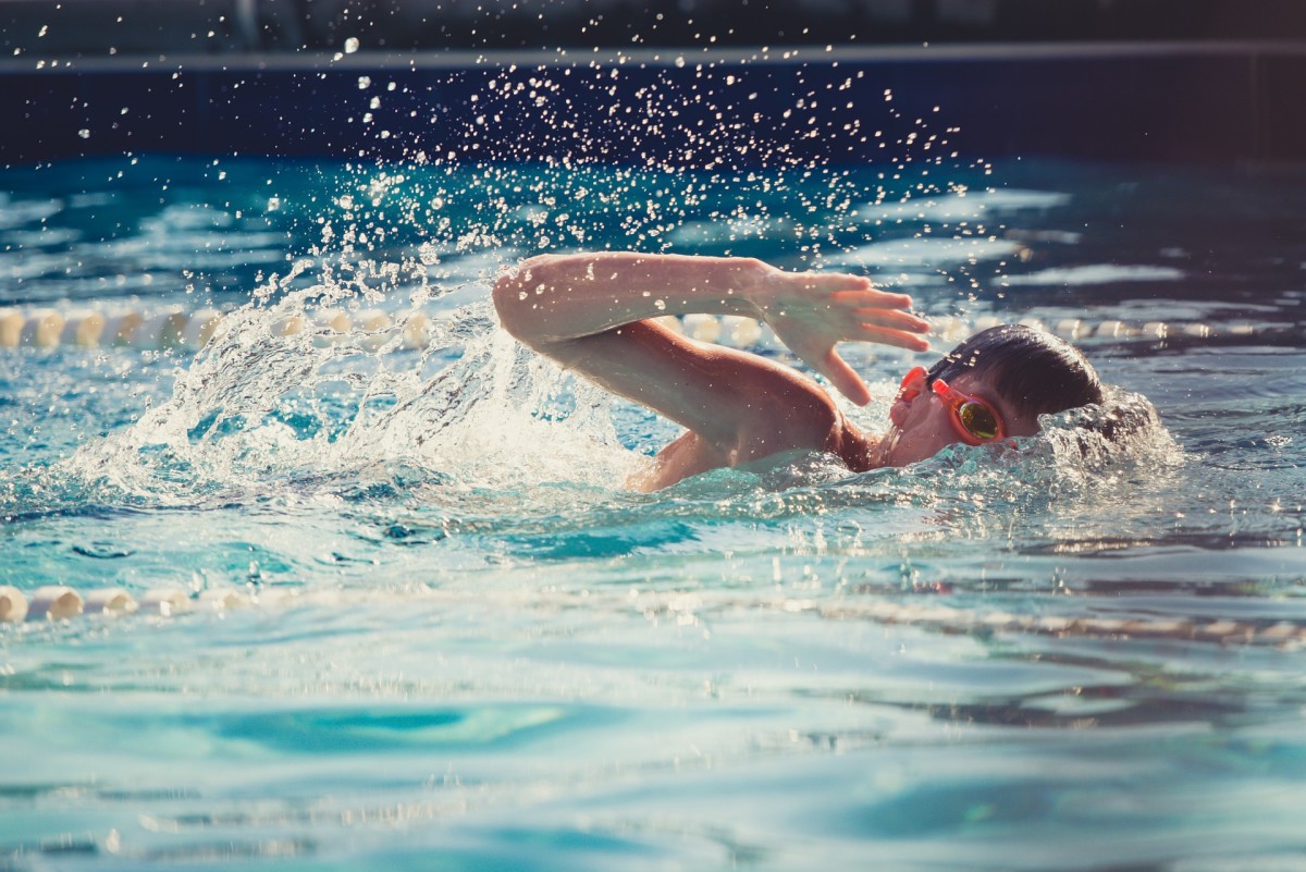A child actively using the freestyle stroke to move through the water.   
