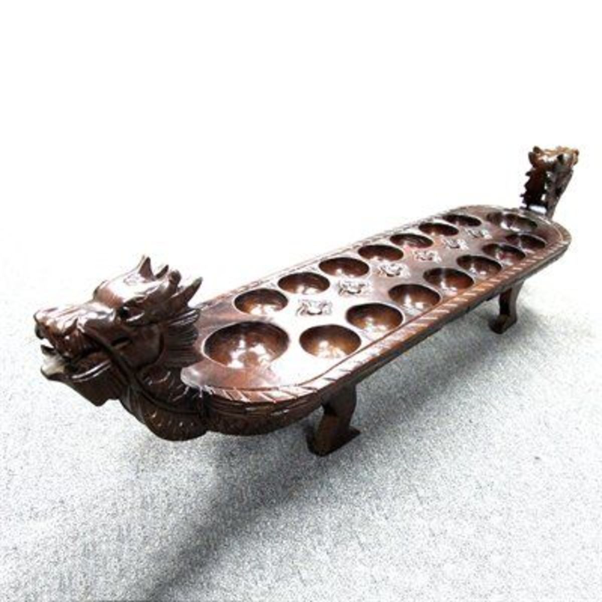 Other Mancala game boards are intricately carved out of wood.