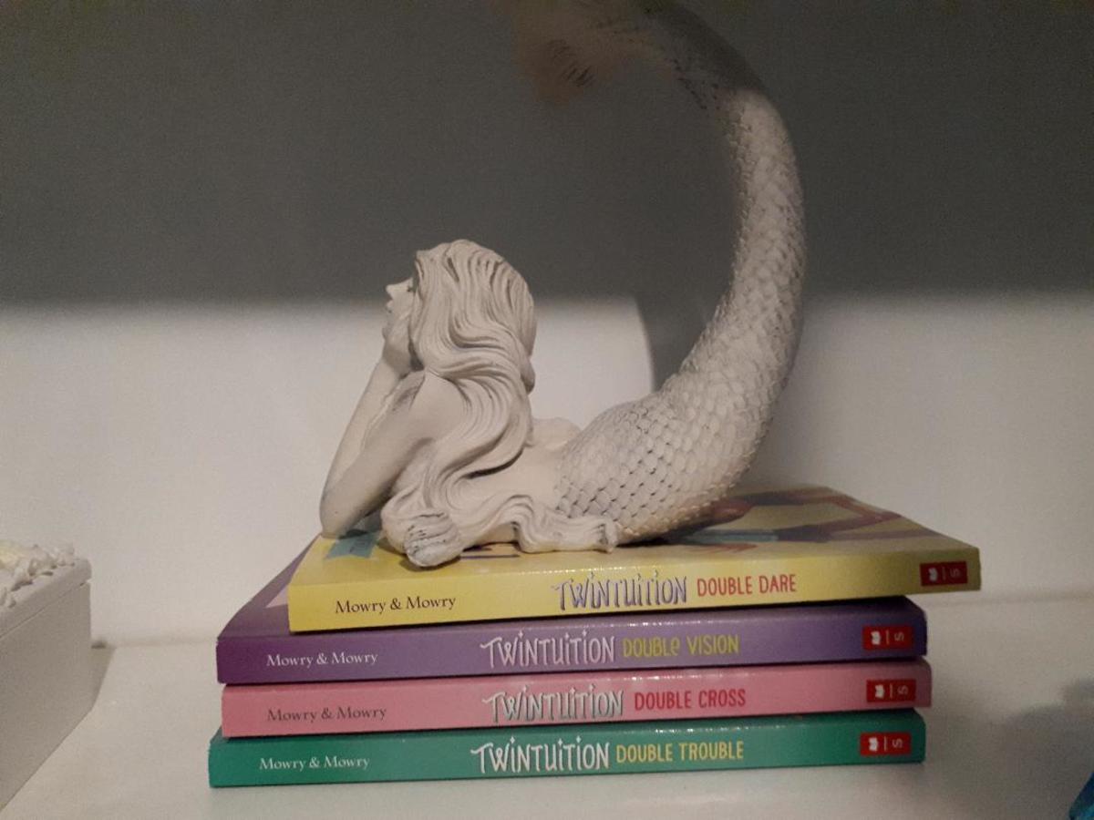 Mermaid statue sitting on books.