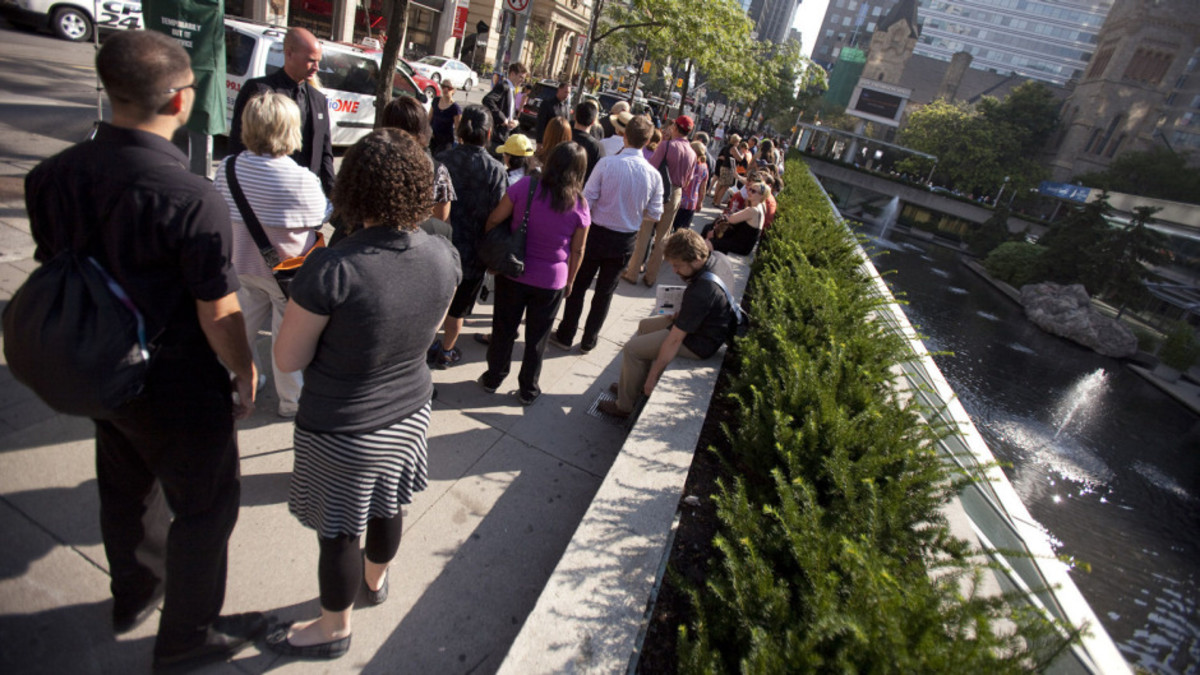Hundreds of people que outside Roy Thomson Hall August 27, 2011, to obtain tickets for the state funeral for Mr. Layton.