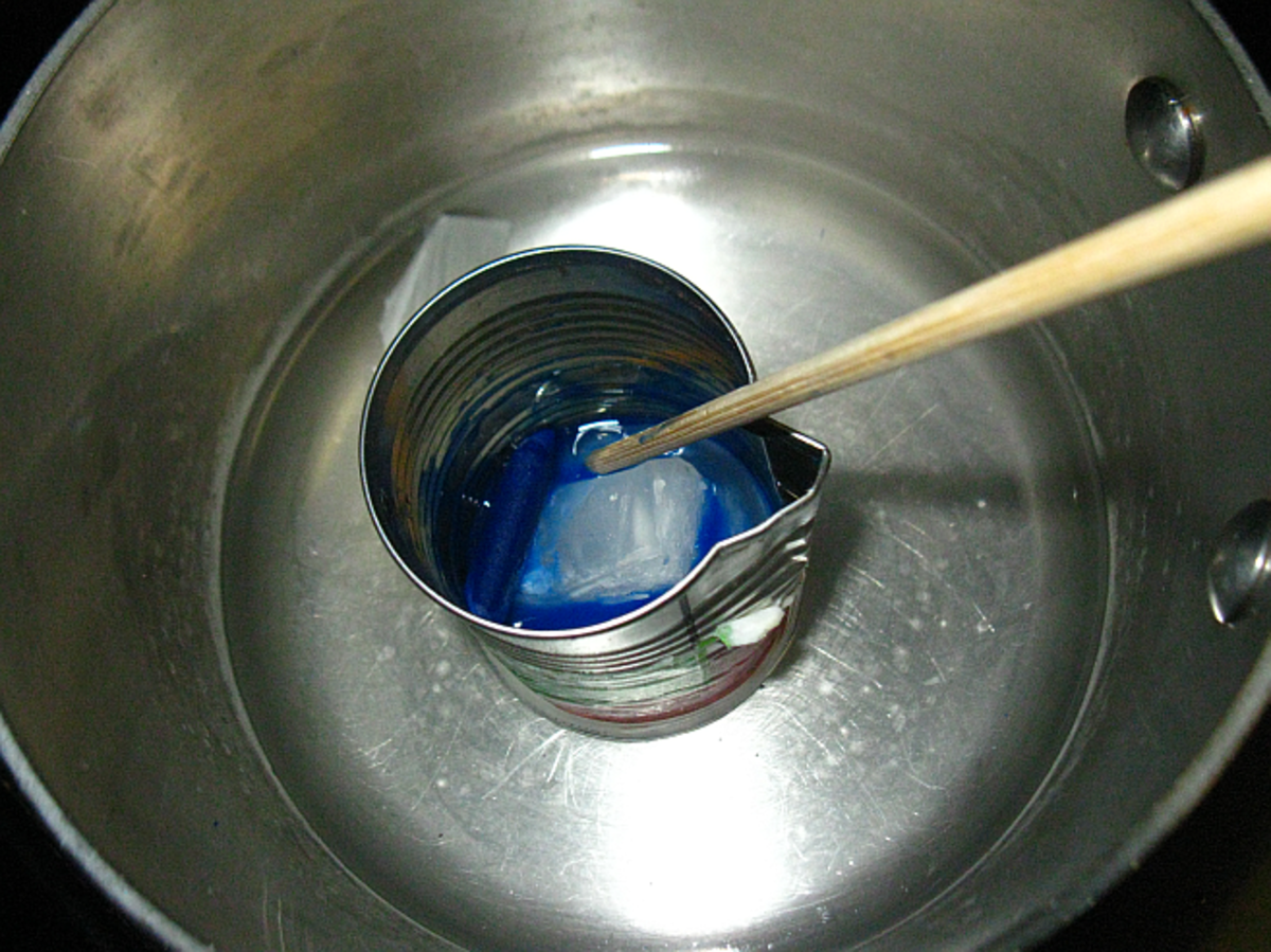 stir melting wax with wooder stirrer to mix in crayon