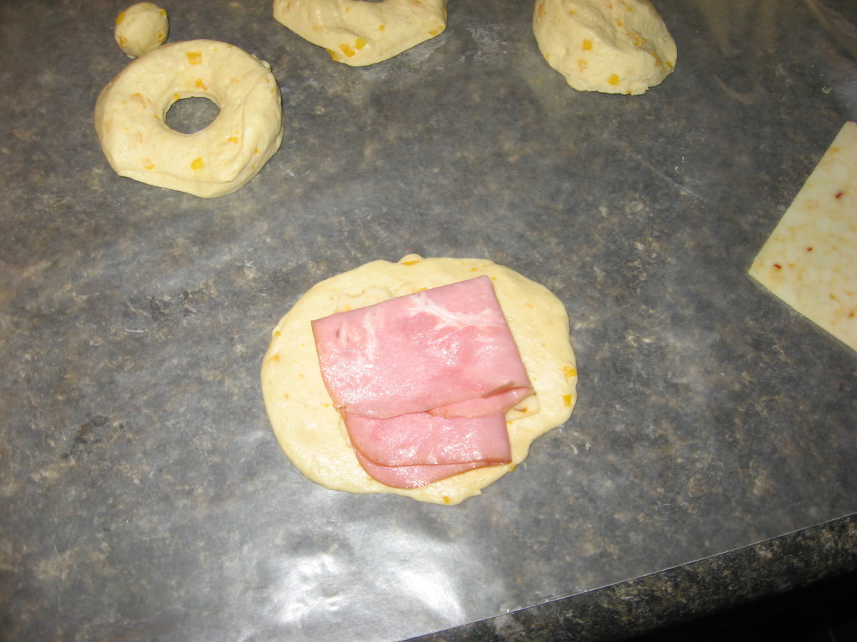 Place ham and cheese on a flattened biscuit.