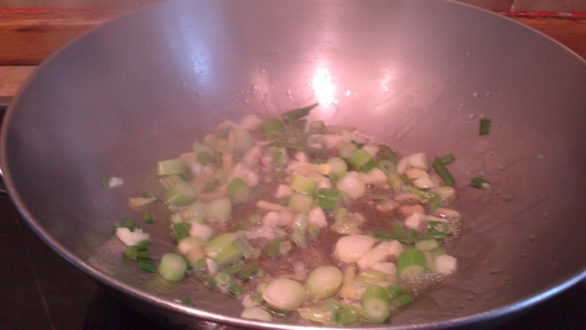 Stir frying the garlic, ginger and spring onions