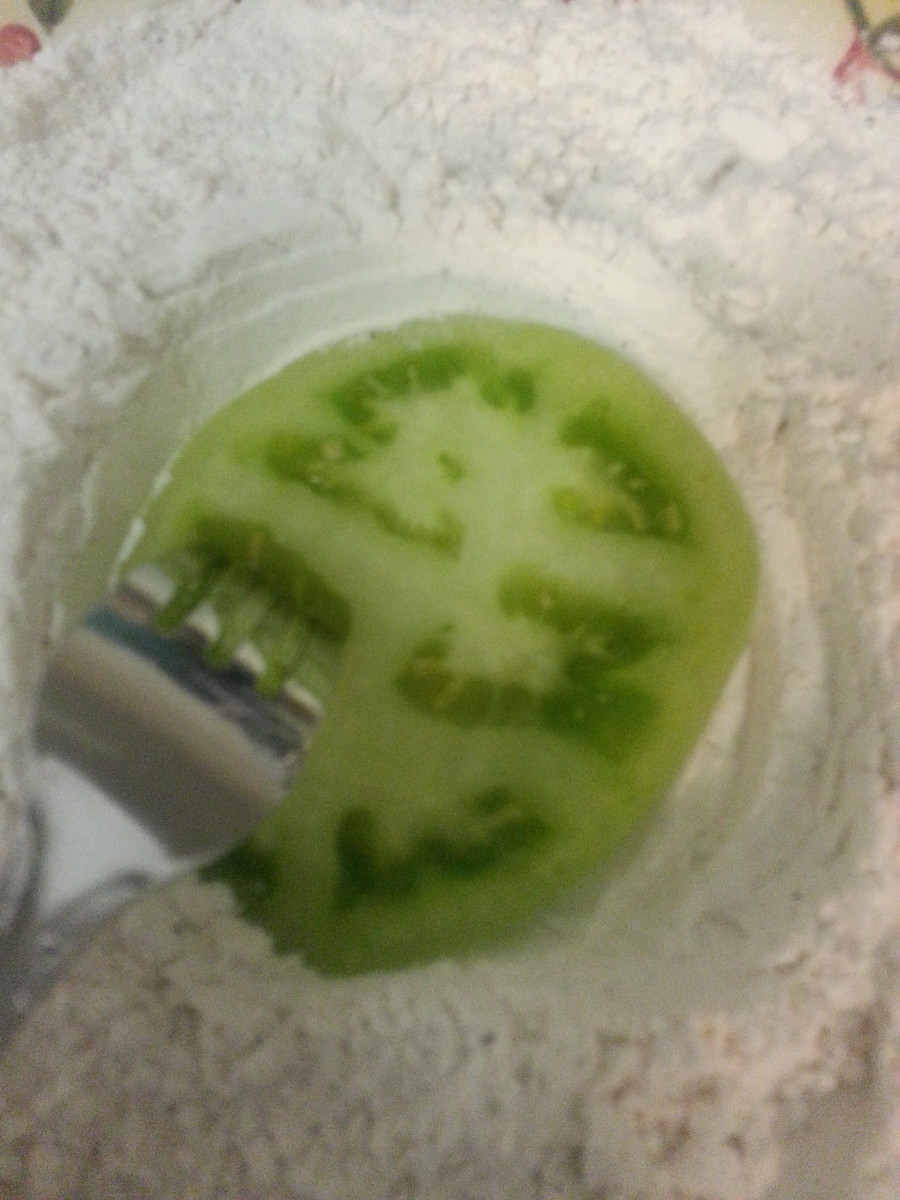 Slice of green tomato in mixture of flour, Kosher salt and black pepper