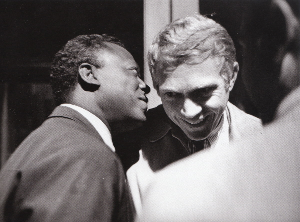 Miles Davis talking sh**t, probably about some chick, to Steve McQueen backstage at the Monterey Jazz Festival, 1963.