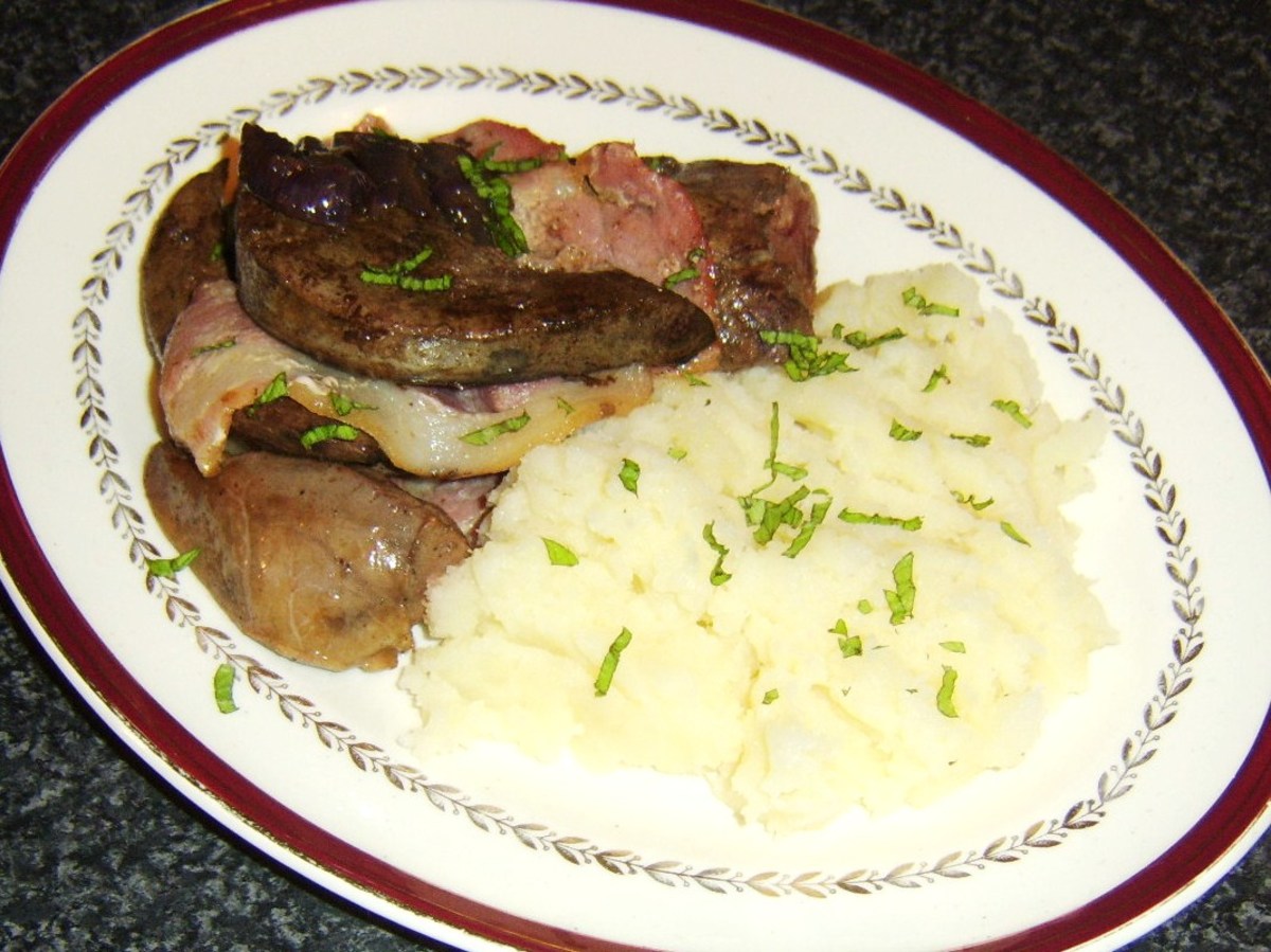 Lambs heart and liver pieces have been fried with bacon and are served with simple red onion gravy and mashed potatoes