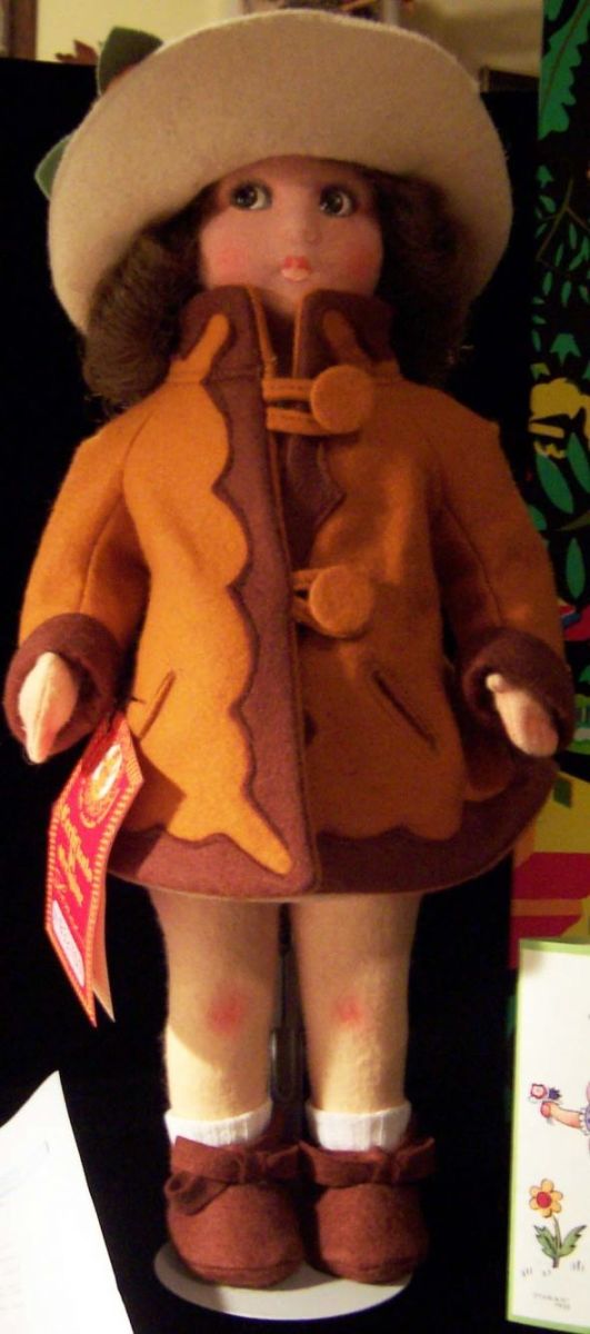 This is a lovely Lenci doll in an orange and brown jacket.