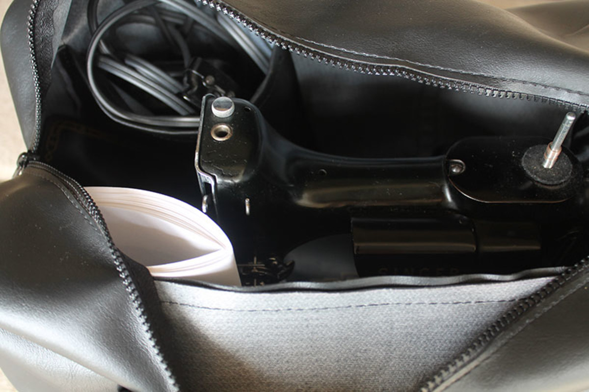 Inside of the Featherweight sewing machine travel bag shows compartments to hold the foot pedal and manuals.