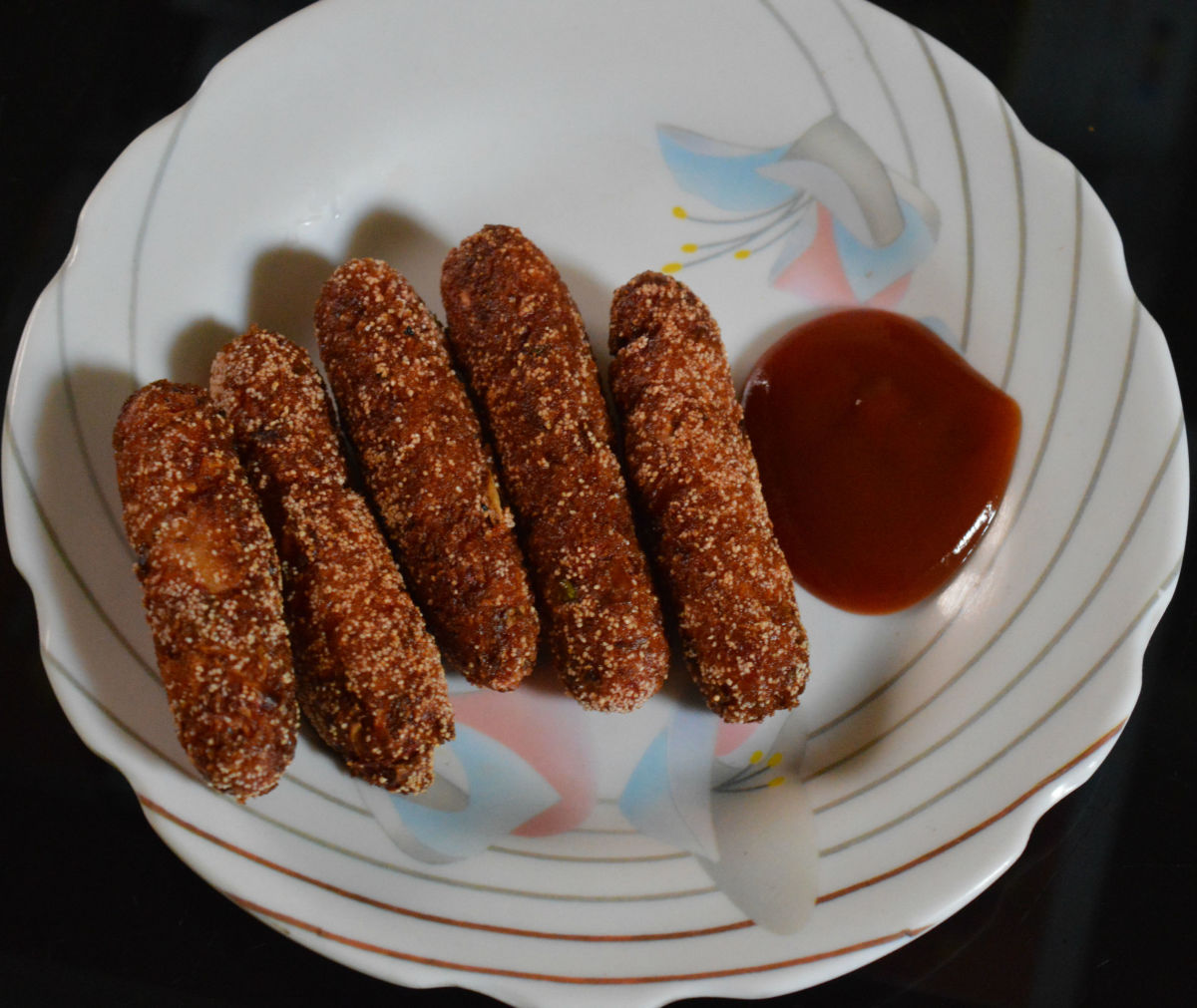 Step two: Mix bread crumbs and semolina. Roll the bullets in it. Deep fry them in medium hot oil for 3-4 minutes. Remove them on absorbent paper. Serve them hot with tomato sauce. They are scrumptious snacks.