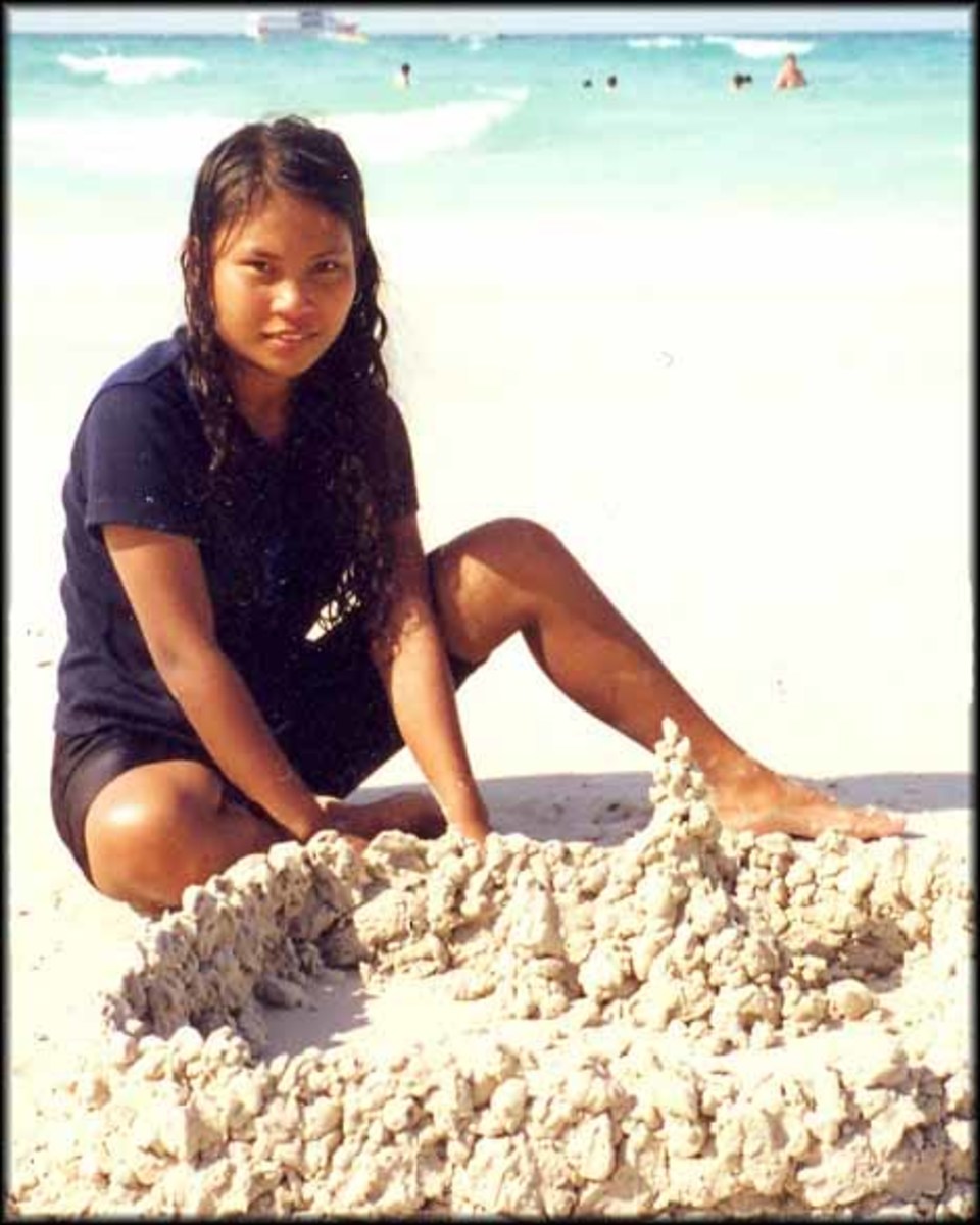 Lon, aged 16, builds sandcastles on the beach in Pattaya 