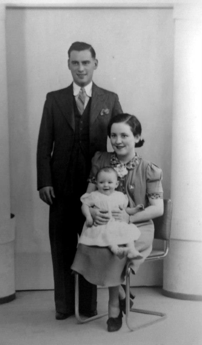 My grandad's youngest brother, Willie Trigg, with his wife Mary and baby daughter Patricia Trigg in a posed studio photograph to celebrate Pat's christening.