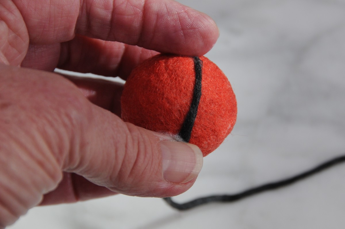 Wrap the wool firmly around the ball and secure the end using a needle felting needle