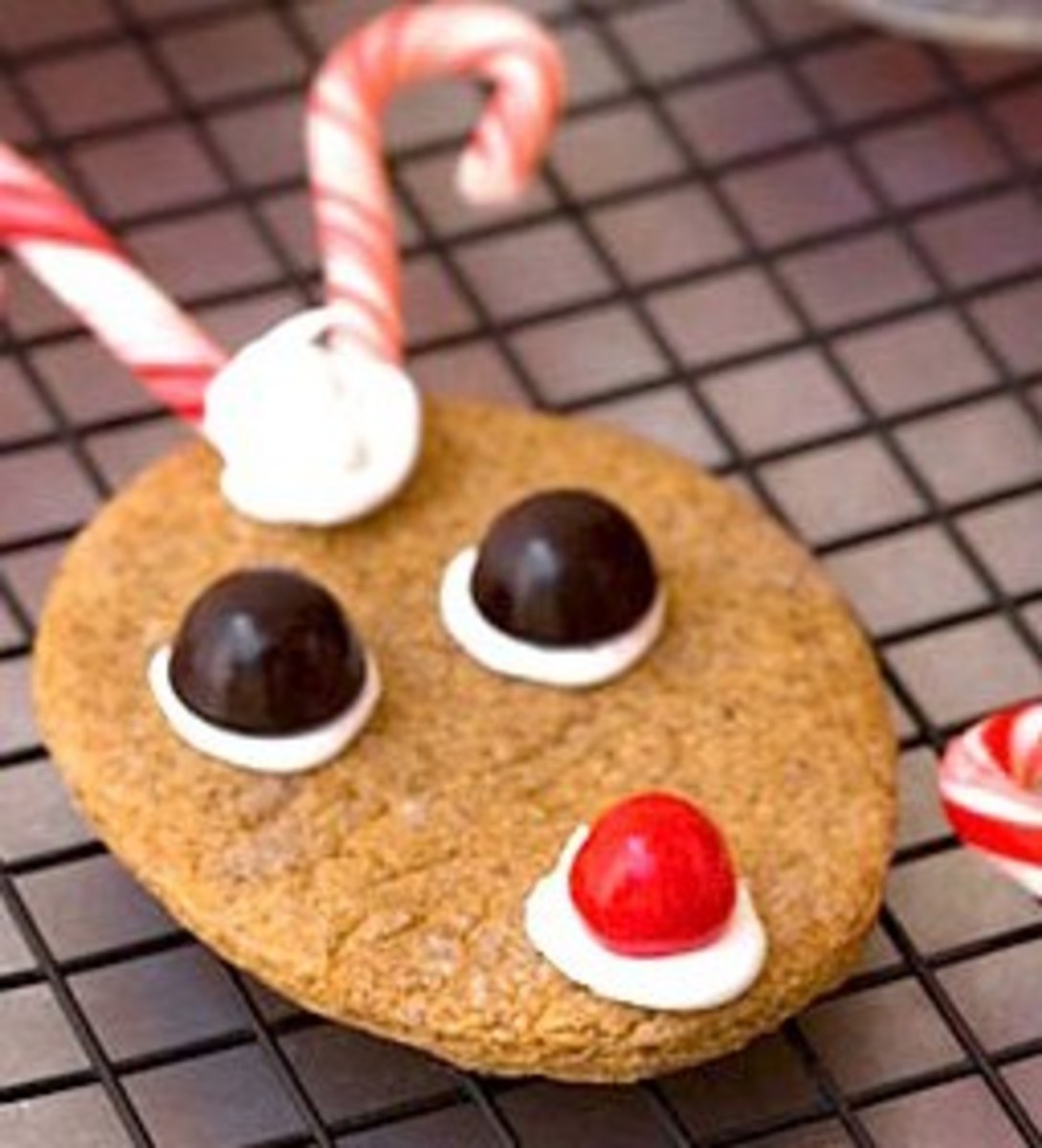 Easy Reindeer cookies made from gingersnap cookies. Icing holds on the chocolate candy eyes, nose and peppermint candy cane antlers.