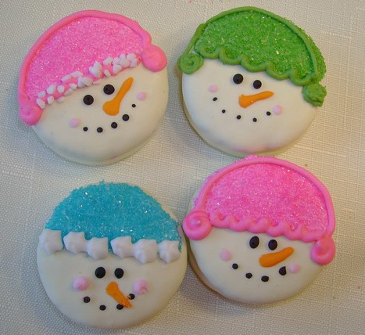 Easy snowman cookies made from Oreos dipped in white chocolate. Hats made from colored sprinkles.