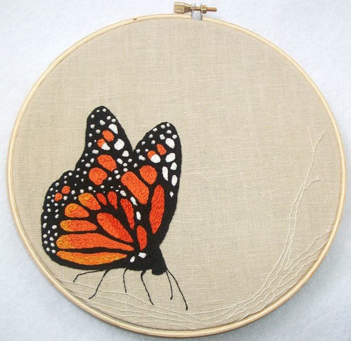 This beautiful butterfly is made up of 'lots of split stitches, some french knots, and a few back stitches' on reclaimed linen.