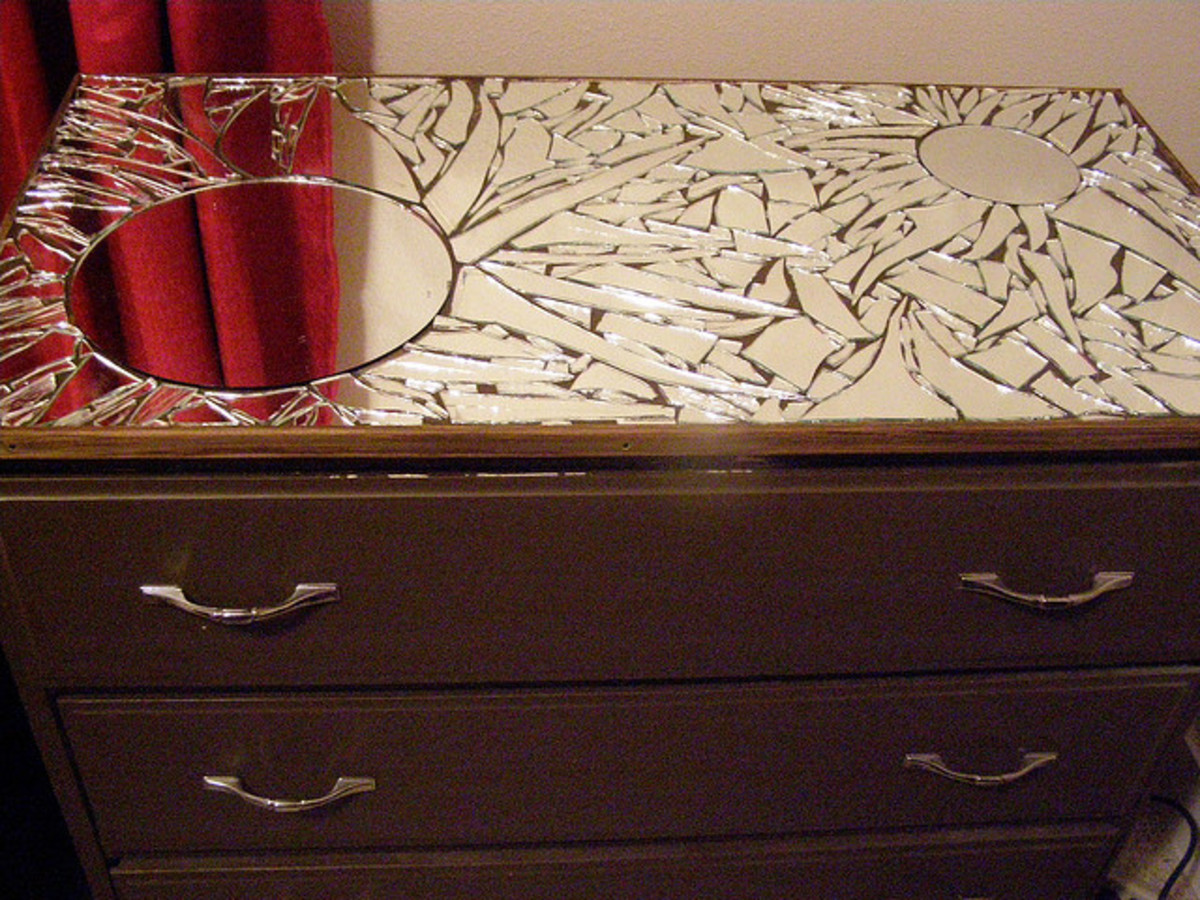 Mirror pieces are stuck to the top of a dresser before it is grouted.