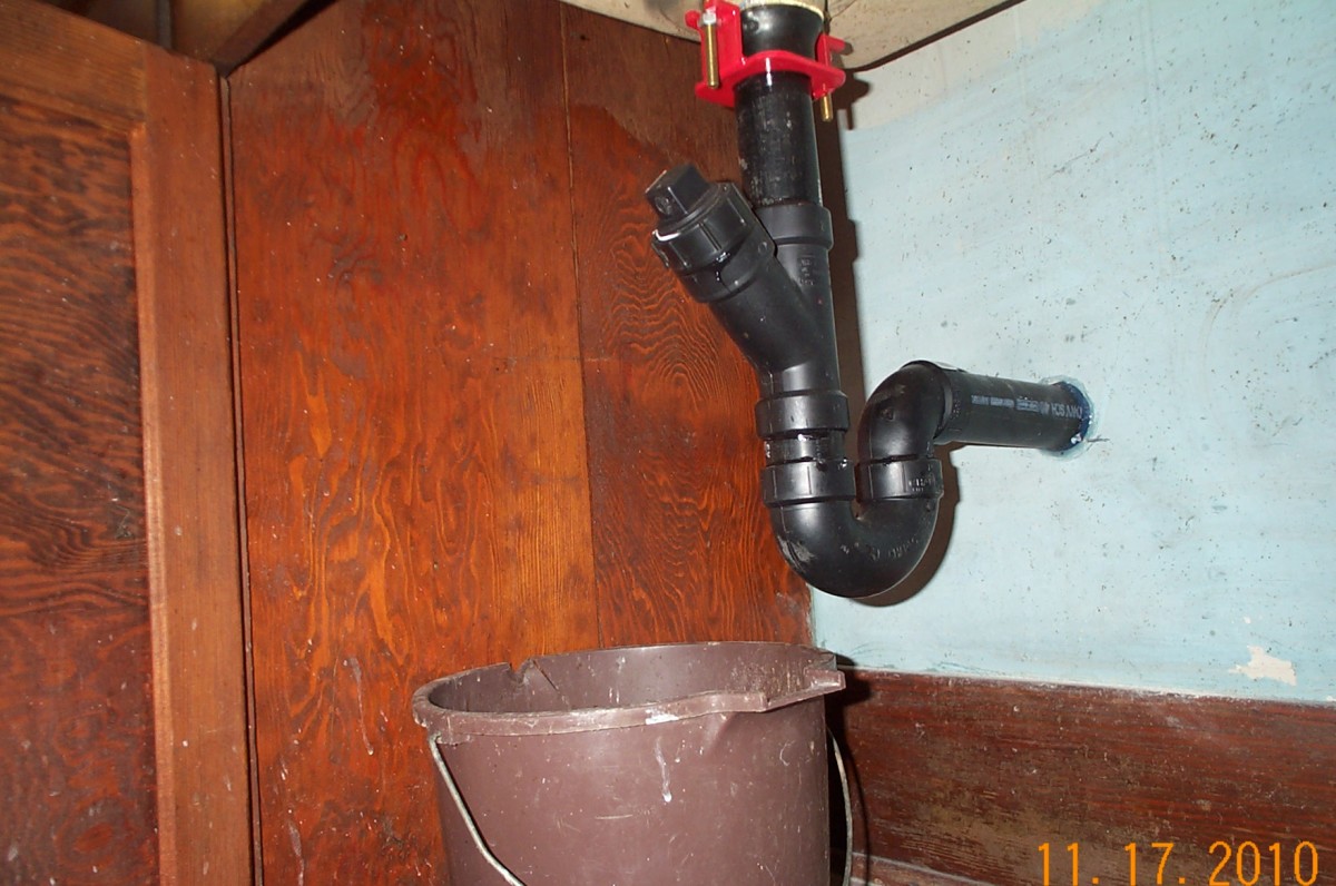 This sink had never actually had plumbing installed under it. The previous residents had used a bucket to catch the waste water . . . maybe even this same brown scrub bucket which we found in the house.