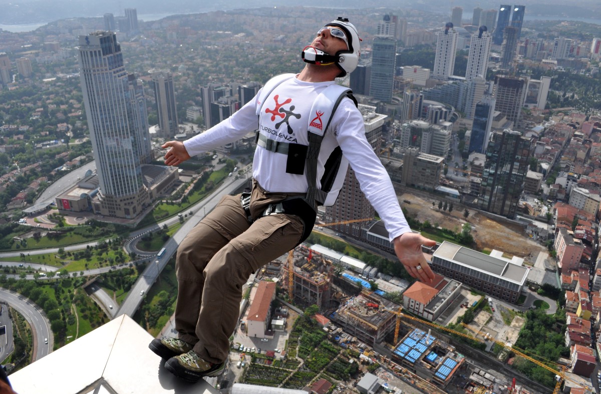 A thrill-seeker BASE jumps from a tower.