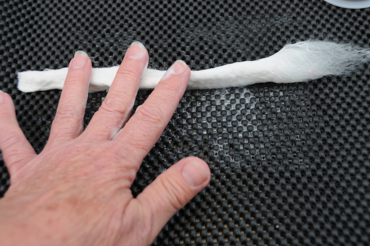 Wet fibers being rolled, keeping one end soft.