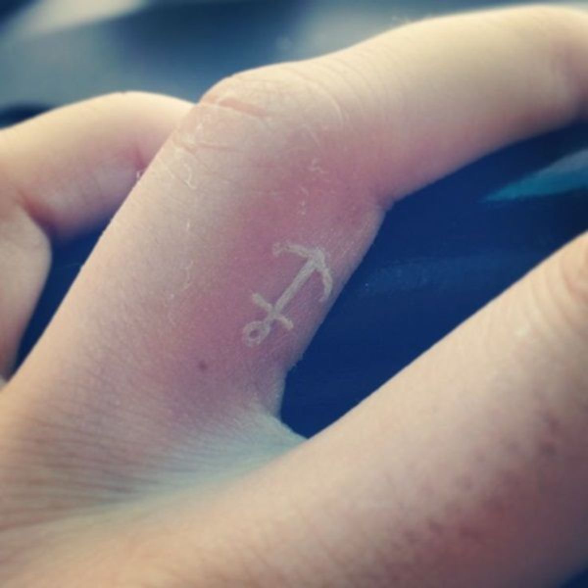 Anchor tattoo at the finger.