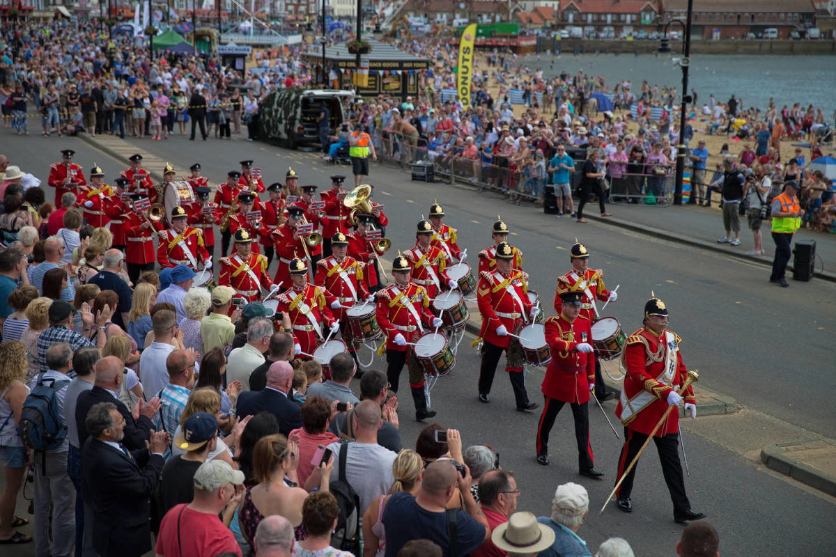A military band takes a march-past along the harbour front at Scarborough