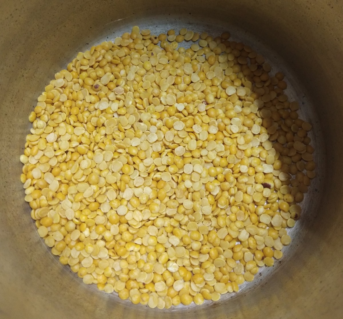 Add one cup of toor dal (pigeon pea lentils) in a cooker.