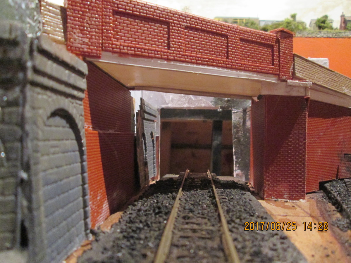 The view along to and under the brick bridge. A stone abutment on the left shows where an older bridge might have stood - removed to make way for the goods shed and siding