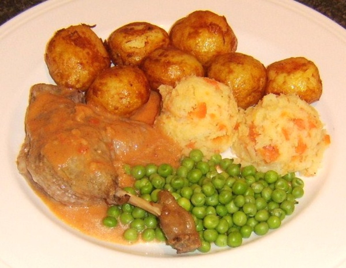 Casseroled duck leg with plum sauce, roast potatoes and vegetables