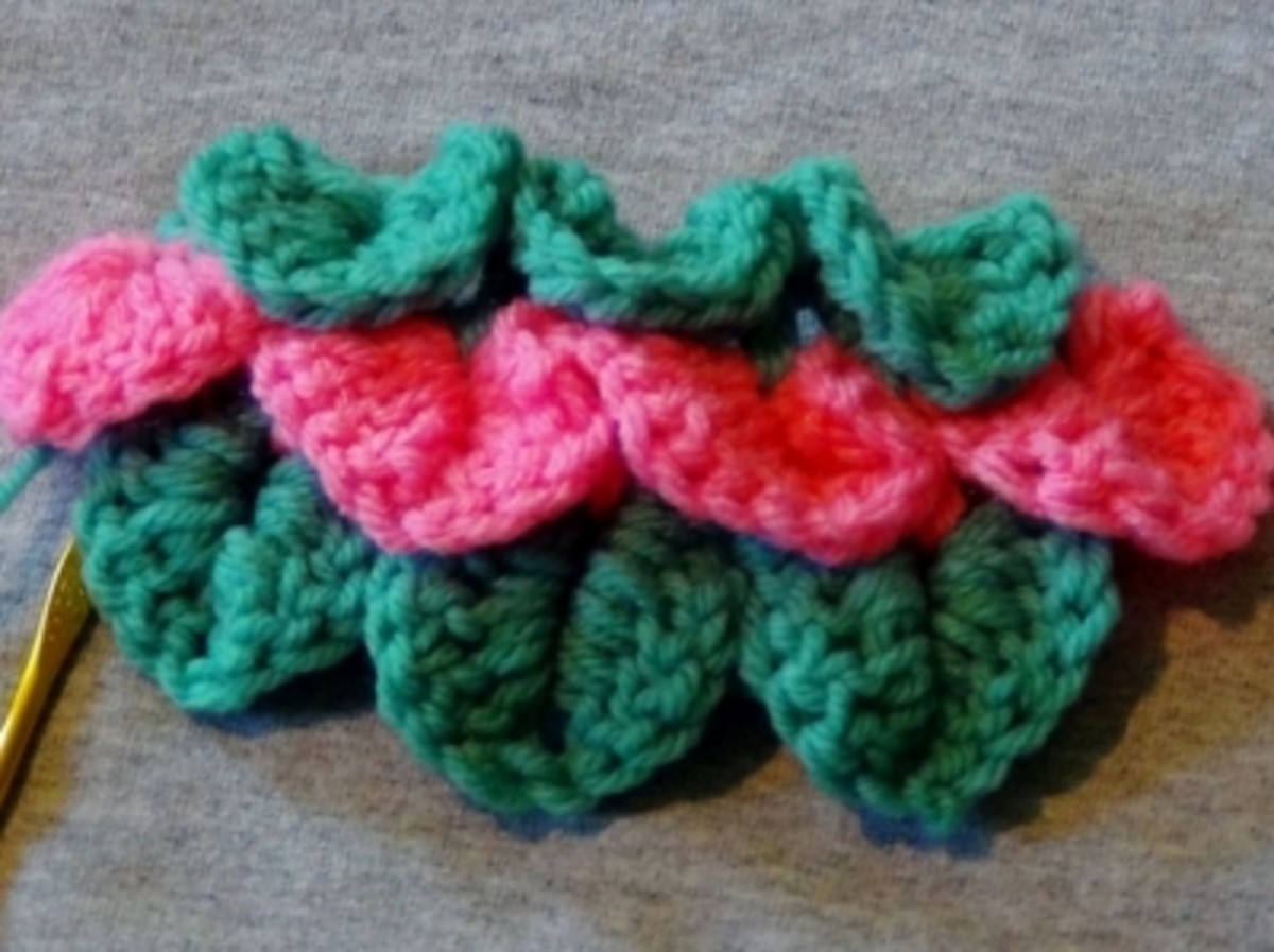 Three completed sets of of crocodile stitches in green and pink, perfect for a little girl's project. This stitch can be used for hems of dresses, tops of baby booties, purses, scarf embellishment, and many other projects.